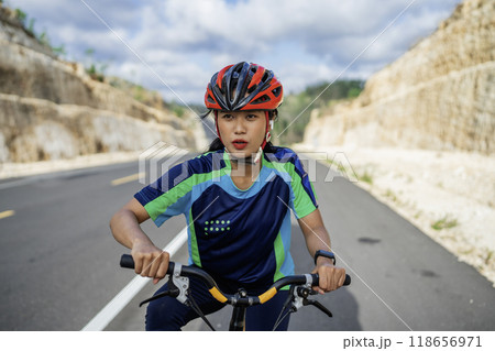 female biker biking with hand on handle bar female biker biking with hand on handle bar 118656971