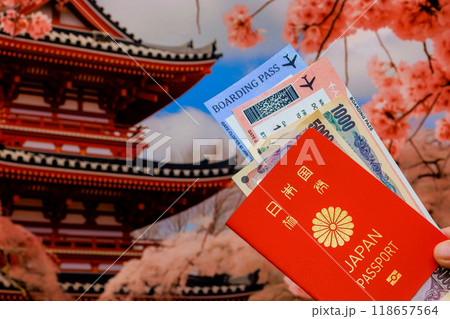 Tourist holds Japanese yen, Japan passport, tickets on background of Japanese old house 118657564