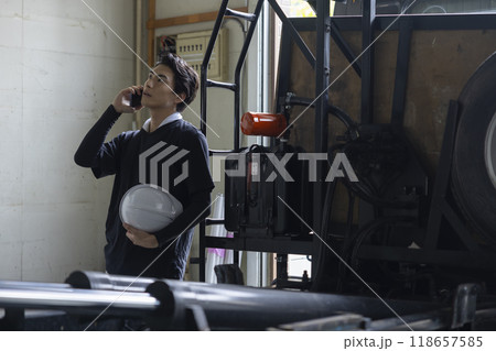 電話をする作業員の男性 118657585