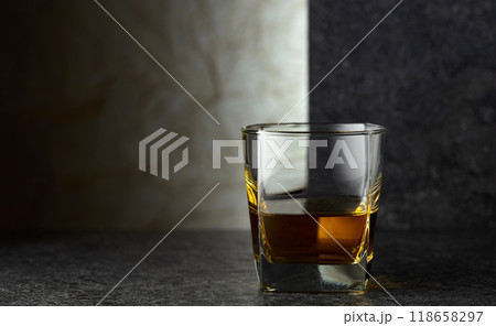 Glass of whiskey on a black table. 118658297