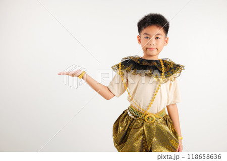 Portrait Thailand kid boy smiling traditional Thai dress costume presenting product holding something on palm away side, studio isolated white background, primary child show hand gesture 118658636
