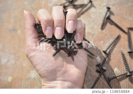 selective focus at the female hand, holding screws, concept of strong 118658884