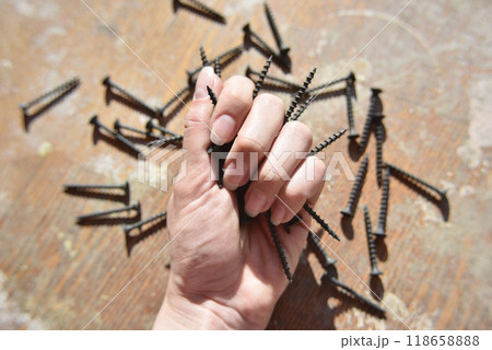 selective focus at the female hand, holding screws 118658888