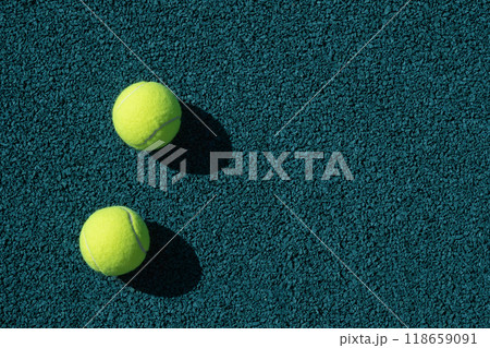 Two yellow tennis balls on green sports ground with artificial grass covering. Close up. Copy space. Healthy lifestyle concept. 118659091