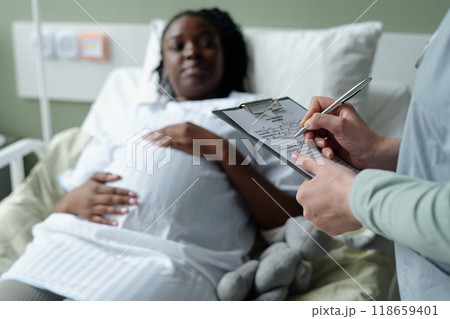 Pregnant Woman Talking with Doctor in Hospital Room 118659401