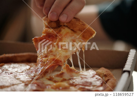 Taking slice of tasty pizza from box 118659527