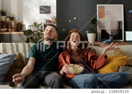 Dates having fun with popcorn on sofa Dates having fun with popcorn on sofa 118659529