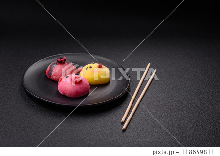 Delicious cold Japanese mochi dessert with colorful rice dough shell and fruit filling Delicious cold Japanese mochi dessert with colorful rice dough shell and fruit filling 118659811