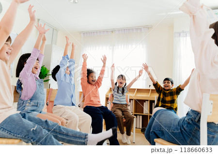 Excited primary school kids from various backgrounds express happiness together. Cheerful classroom scene captures essence of modern education, highlighting unity and active participation Excited primary school kids from various backgrounds express happiness together. Cheerful classroom scene captures essence of modern education, highlighting unity and active participation 118660633