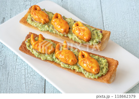 Guacamole toasts with crab claws 118662379