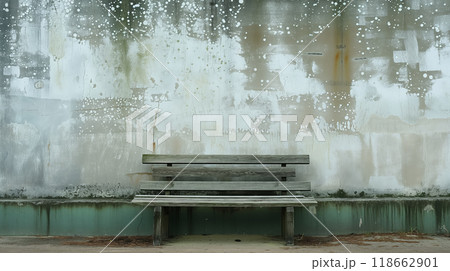 Old bench against a weathered and painted wall. 118662901