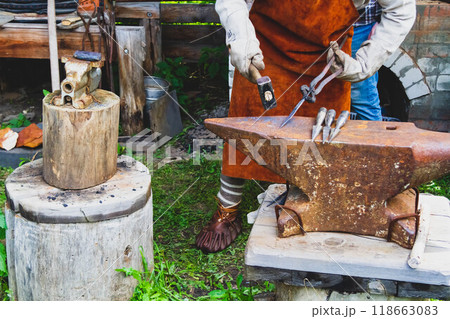 A blacksmith forges iron. Blacksmith's workshop. Blacksmith's anvil and hammer. A blacksmith forges iron. Blacksmith's workshop. Blacksmith's anvil and hammer. 118663083