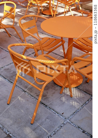 Coffee shop restaurant, orange furniture tables and chairs for guests. cozy street with cafe tables Coffee shop restaurant, orange furniture tables and chairs for guests. cozy street with cafe tables 118663368