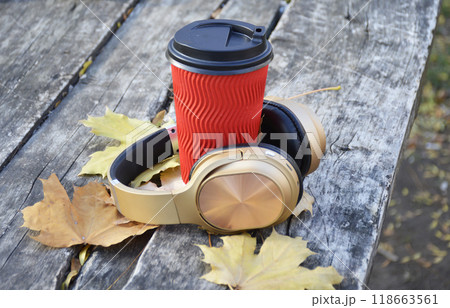 tea, coffee or cappuccino and wireless headphones on yellow autumn leaves tea, coffee or cappuccino and wireless headphones on yellow autumn leaves 118663561