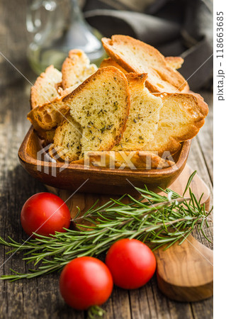 Crispy roasted bruschetta bread in bowl on wooden table. 118663685