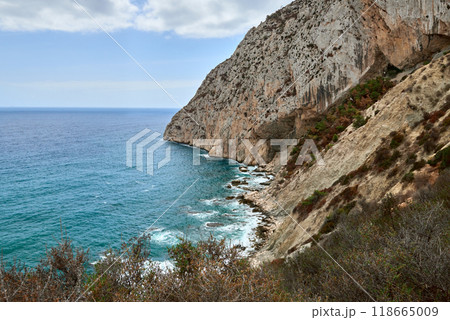 Scenic cliffside perspective overlooking the turquoise waters and waves below with a vibrant blue sky and natural landscape ideal for travel photography 118665009