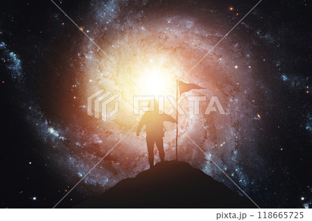 Silhouette of an astronaut with a flag against the background of the galaxy. Elements of this image furnished by NASA 118665725