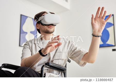 Portrait of man with disability using VR technology and interacting with invisible digital art piece in modern art museum setting 118666487