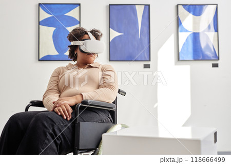 Minimal portrait of Black woman with disability using VR in modern art exhibition and looking at invisible artwork on podium copy space 118666499