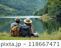 Couple of hikers relaxing by the lake enjoying the view 118667471