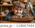 Smiling child posing with wooden toy ship 118667484