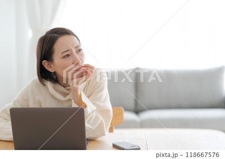 パソコンを見て考える表情の女性 パソコンを見て考える表情の女性 118667576