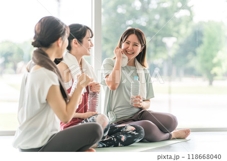 スポーツジムのヨガ教室で休憩をしながら水分補給・スポーツドリンクを飲む女性達 118668040