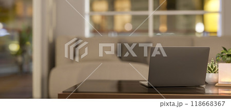 A back view of a laptop on a coffee table in a cozy, contemporary living room. A back view of a laptop on a coffee table in a cozy, contemporary living room. 118668367