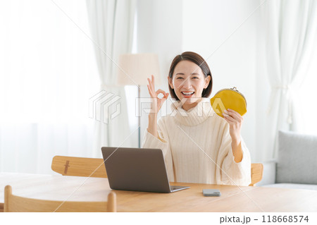 財布を持ち微笑む女性 118668574