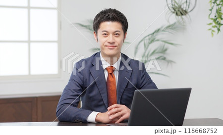 手を止め話を聞くビジネスマン 118668752