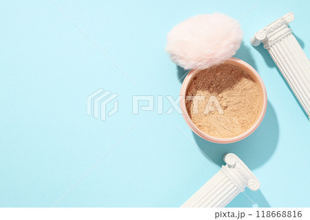 A bottle of loose powder, light shade, on a blue background. A bottle of loose powder, light shade, on a blue background. 118668816