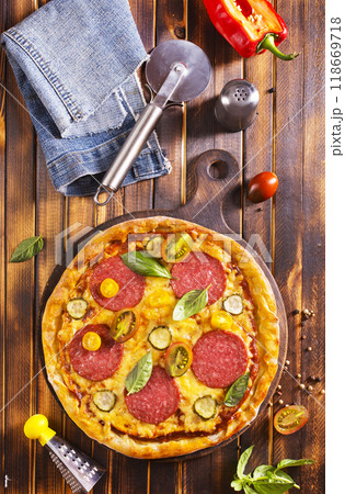 Tasty pepperoni pizza with basil on wooden table 118669718