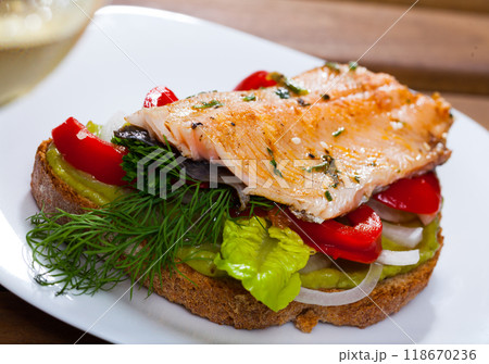 Tasty piece of bread with fried trout fillet Tasty piece of bread with fried trout fillet 118670236
