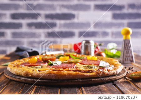 Tasty pepperoni pizza with basil on wooden table 118670237