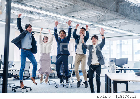 オフィスで大喜びをしてジャンプをするビジネスパーソン 118670313