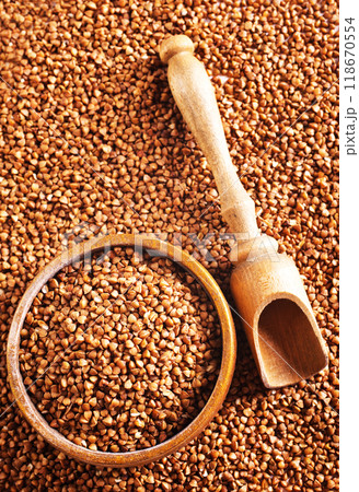 Wooden bowl full of raw wholegrain buckwheat groats 118670554