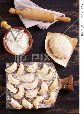 Raw dumplings varenik - traditional Ukrainian food - on wooden board close up. 118670565