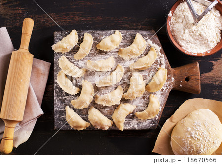 Raw dumplings varenik - traditional Ukrainian food - on wooden board close up. Raw dumplings varenik - traditional Ukrainian food - on wooden board close up. 118670566