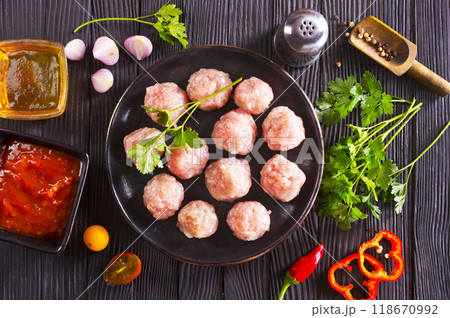 Fresh raw beef meatballs with spices and tomato sauce Fresh raw beef meatballs with spices and tomato sauce 118670992