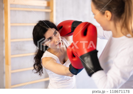 Portrait of sportswomen competing in colored boxing gloves Portrait of sportswomen competing in colored boxing gloves 118671178