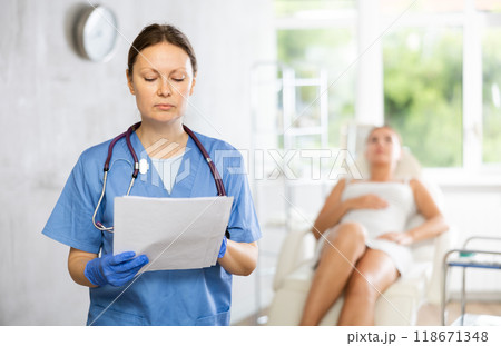Adult woman doctor posing with contract in medical room 118671348