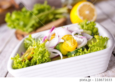 Bright juicy salad with yellow cherry tomatoes and aromatic basil leaves in bowl. Bright juicy salad with yellow cherry tomatoes and aromatic basil leaves in bowl. 118671633