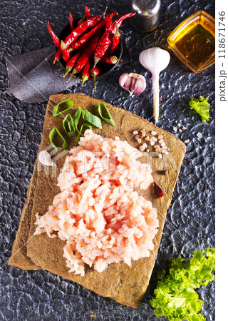 Raw minced meat in bowl on dark table and ingredients. Raw minced meat in bowl on dark table and ingredients. 118671746