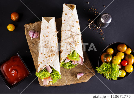 wrap sandwich with ham, lettuce, tomatoes and cheeses wrap sandwich with ham, lettuce, tomatoes and cheeses 118671779