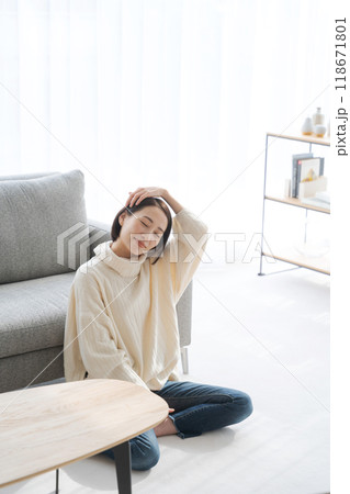 リビングの床に座ってくつろぐ女性 リビングの床に座ってくつろぐ女性 118671801