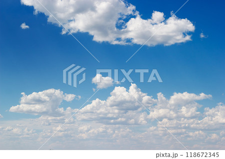 An azure sky filled with fluffy white cumulus clouds stretches. An azure sky filled with fluffy white cumulus clouds stretches. 118672345
