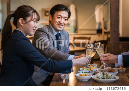 居酒屋で忘年会・新年会・飲み会・宴会をする仕事仲間・同僚・上司部下の男女 118672416