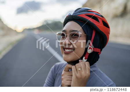 close up hijab biker wearing helmet for safety close up hijab biker wearing helmet for safety 118672448