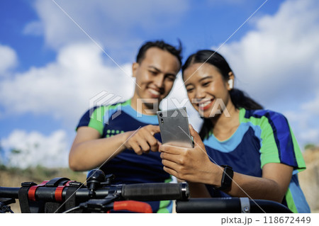 couple biker using phone for maps couple biker using phone for maps 118672449