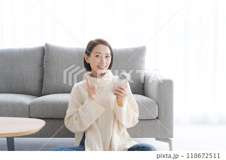 リビングでスマホを操作する女性 118672511